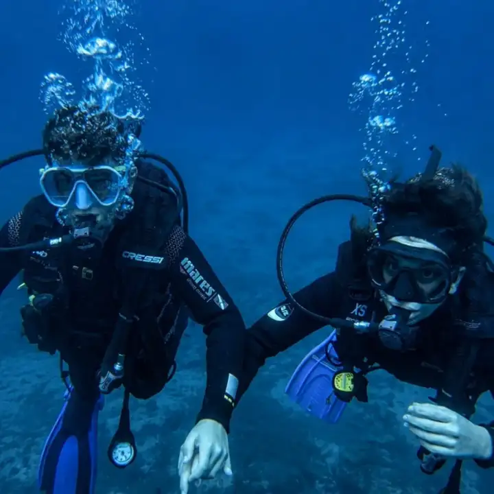 Dos alumnos de buceo acompaÃ±ados bajo el agua en La Herradura